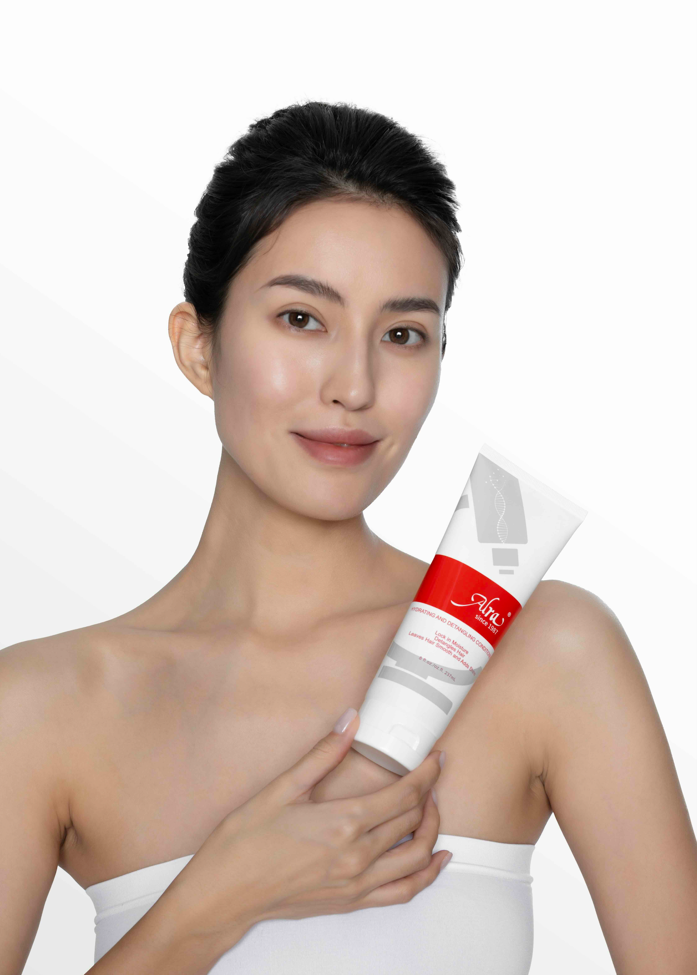 Woman holding Alra Hydrating and Detangling Conditioner, showcasing clean and healthy skin